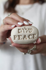 Handcrafted ceramic stone with Peace (שלום) in Hebrew and English – perfect for home or spiritual spaces